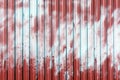 Fence from corrugated metal. The surface is painted in red and light blue. Paint spots. Royalty Free Stock Photo