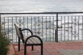 A fence and an empty bench against the backdrop of sea waves. Alanya, November 2021. Royalty Free Stock Photo