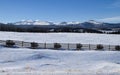 Fence in front of mountains on snowy day Royalty Free Stock Photo