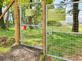 Fence and gate with signs outside a secure dog walking field, where dogs can run free for a fee