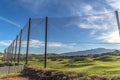 Fence with golf course homes and mountain against blue sky on the other side Royalty Free Stock Photo