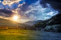 Fence through the grassy meadow in mountains time change concept Royalty Free Stock Photo