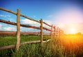 Fence in the green field under blue cloud sky Royalty Free Stock Photo