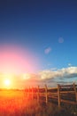 Fence in the green field under blue cloud sky Royalty Free Stock Photo