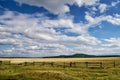 Fence in the green field under blue cloud sky. Beautiful landscape Royalty Free Stock Photo