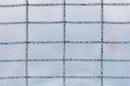 A fence with a grid pattern is covered in ice Royalty Free Stock Photo