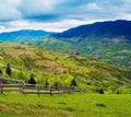 Fence on hillside meadow.