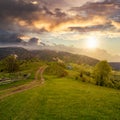 Fence on hillside meadow in mountain at sunset Royalty Free Stock Photo