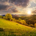 Fence on hillside meadow in mountain at sunset Royalty Free Stock Photo