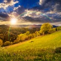 Fence on hillside meadow in mountain at sunset Royalty Free Stock Photo