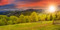 Fence on hillside meadow in mountain at sunset Royalty Free Stock Photo