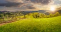 Fence on hillside meadow in mountain at sunset Royalty Free Stock Photo