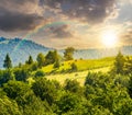 Fence on hillside meadow in mountain at sunset Royalty Free Stock Photo