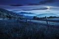 Fence on hillside meadow in mountains at night