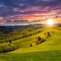 Fence on hillside meadow at sunset