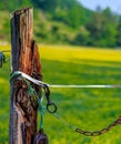 Fence of horse farm with clasps and chains and rotted post Royalty Free Stock Photo