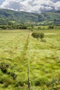 Fence leading to green rocky mountains Royalty Free Stock Photo