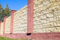 Fence made of bricks and decorative . Yellow with red elements. High and beautiful fencing