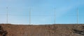 A fence made of metal mesh separates the  sandy quarry pit and the blue sky Royalty Free Stock Photo