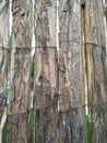 Fence made of tree bark slats and fastened with wire Royalty Free Stock Photo