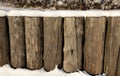 a fence made of vertical logs covered with snow