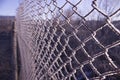 Fence of metal mesh covered with frost. The concept of incarceration behind a frozen metal mesh into custody.