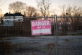 Fence with a sign warning about a danger outdoors Royalty Free Stock Photo