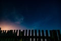 Fence and starry night sky before sunrise