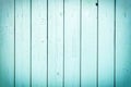 A fence of vertical light turquoise boards. Blank background with a texture of wooden slats.