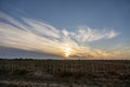 Fenced field under a captivating sunset sky with stunning cloud formation Royalty Free Stock Photo