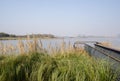 Fenced platform in lakeside weeds on sunny winter day