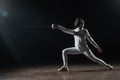 In fencing mask doing lunge while