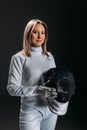 Fencer in fencing suit holding mask