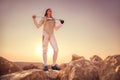 Fencer man standing on top of the rock and holding his sword on the shoulders Royalty Free Stock Photo