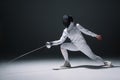 Fencer training under spotlight on black Royalty Free Stock Photo