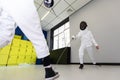 Fencer woman with fencing sword. Fencers duel concept. Royalty Free Stock Photo