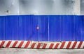 Fencing of construction site with red construction light on the background of blue profiled sheet fence Royalty Free Stock Photo