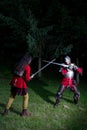 Fencing Duel Between Two Knights in Armor in the Forest Royalty Free Stock Photo