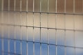 Fencing in the form of a grid on an abandoned football field illuminated by the rays of the setting March sun