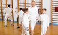 Fencing instructor with young fencers in training room