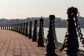 Fencing of sidewalk. the fence of the empty pedestrian promenade in the form of cast-iron posts and a thick iron chain. Royalty Free Stock Photo