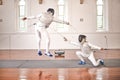 Fencing, sport and jump with sword to fight in training, exercise or workout in a hall. Martial arts, match and fencers