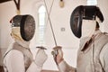 Fencing, sport and start fight with sword in training, exercise or challenge in hall. Martial arts, crossed and fencers