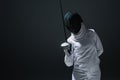 In fencing suit and mask holding