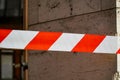 Fencing tape, red and white, on a rocky background,