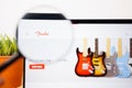 Fender Logo under a magnifying glass. Fender Website on Laptop screen