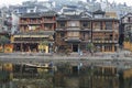 FengHuang, China Feb 21, 2014 traditional chinese houses in Fenghuang village with chinese character signs and asian man in a boat Royalty Free Stock Photo