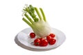 Fennel plant on a plate with tomatoes on a white background