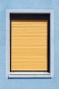Fenster mit braunen heruntergezogenen RollÃÆÃÂ¤den an einer blauen