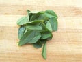 Fenugreek leaves heap on wooden background Royalty Free Stock Photo